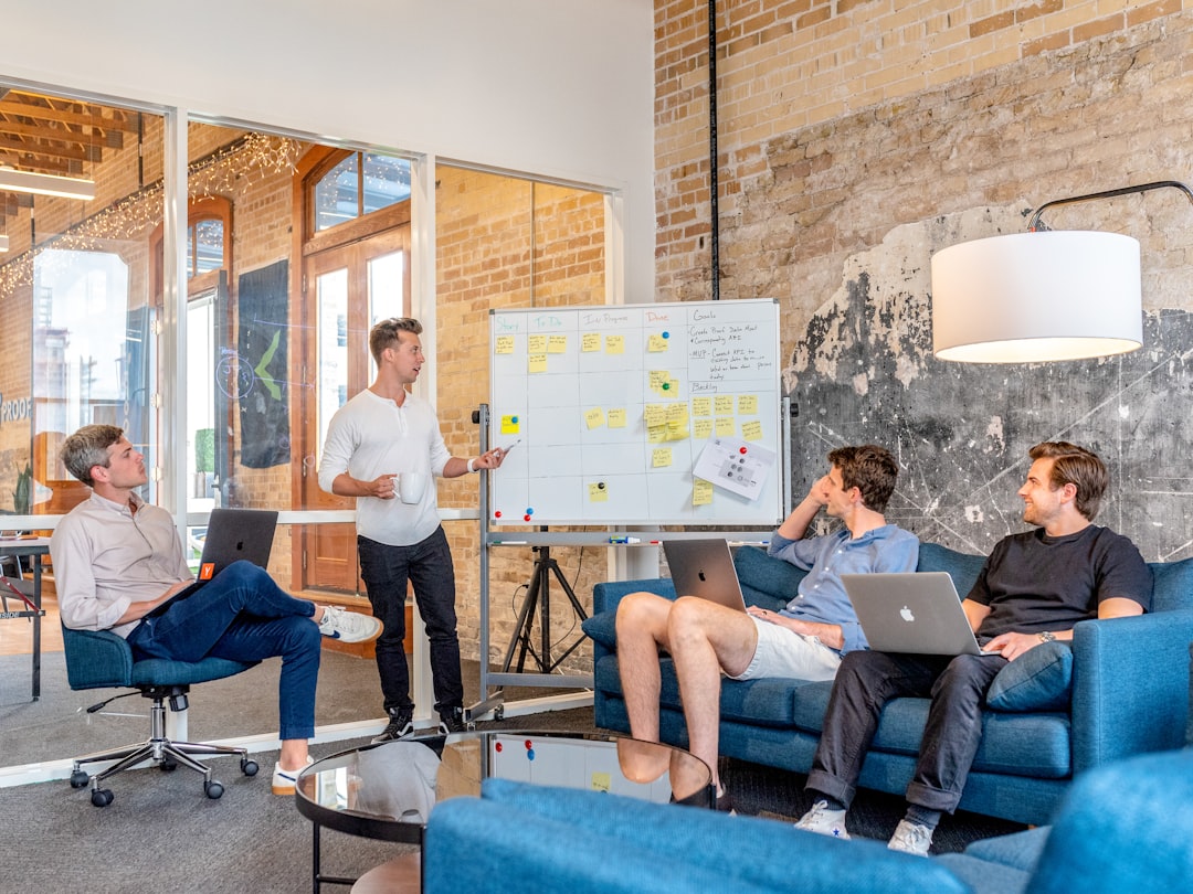 why-choose-us-01 three-men-sitting-while-using-laptops-and-watching-man-beside-whiteboard-wd1lrb9oeeo